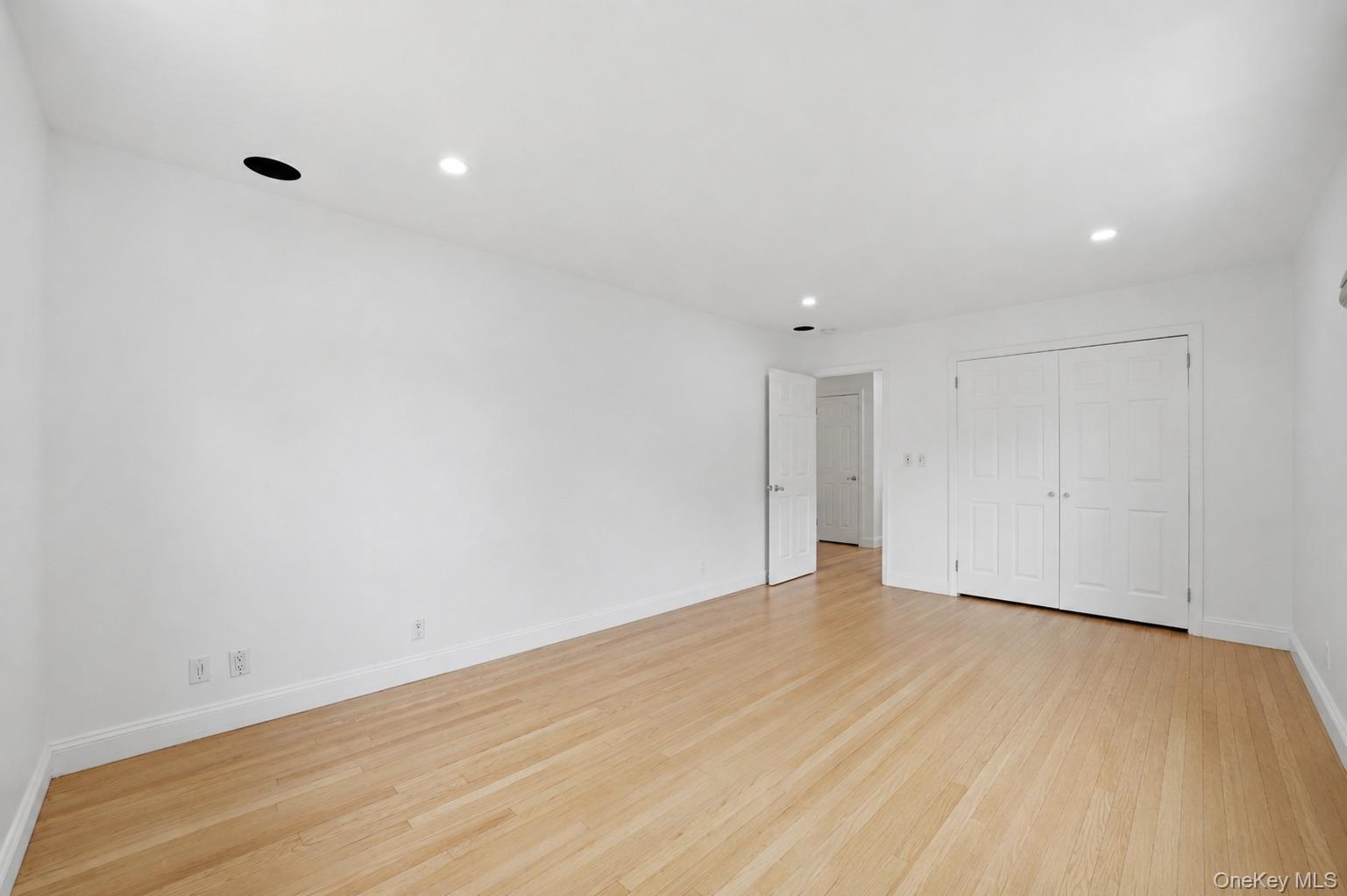 144 Bell Road Scarsdale, NY 10583 - Photo 22 of 49 Expansive room featuring light wood-finish flooring, recessed lighting, white walls, a double-door closet, and white baseboards
