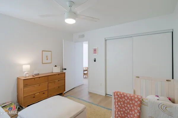 a bedroom with baby bed toys and a window