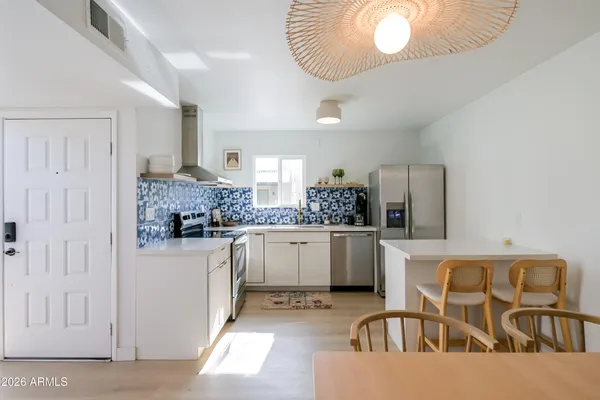a kitchen with white cabinets and chairs