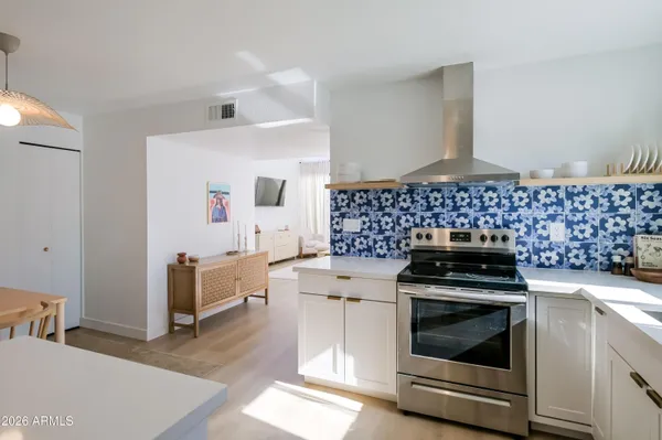 a kitchen with a stove and white cabinets