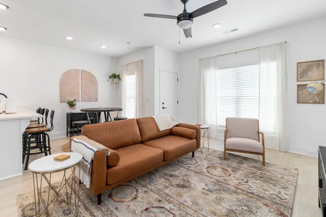 an empty room with wooden floor ceiling fan and windows