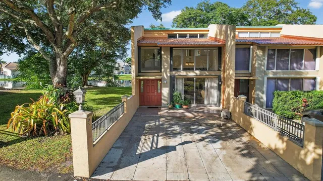 a view of a house with a yard and potted plants