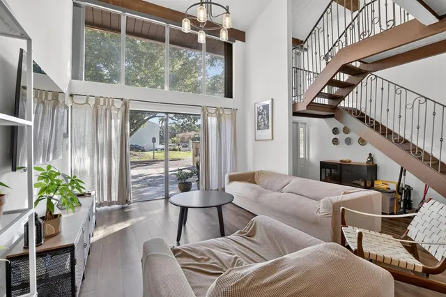 a view of staircase with lots of frames on wall and wooden floor
