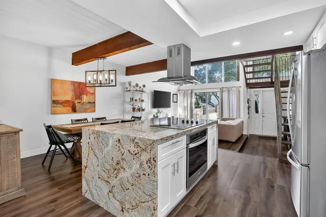 a kitchen with stainless steel appliances granite countertop a stove and a wooden floors