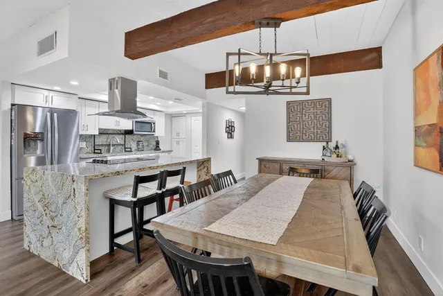 a kitchen with stainless steel appliances granite countertop a sink a stove and a refrigerator