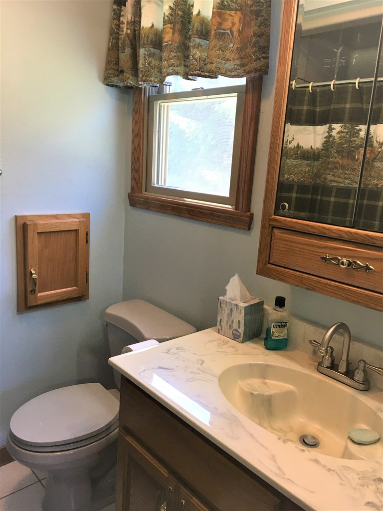 23273 Fry Road Venango, PA 16440 - Photo 46 of 74 a bathroom with a granite countertop toilet sink and mirror