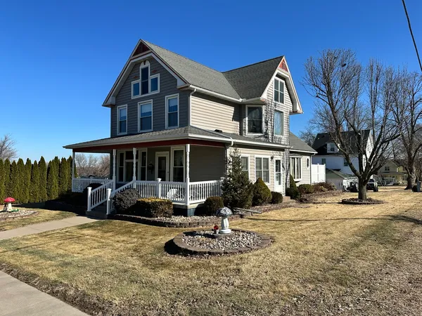 a front view of a house with a yard covered with snow
