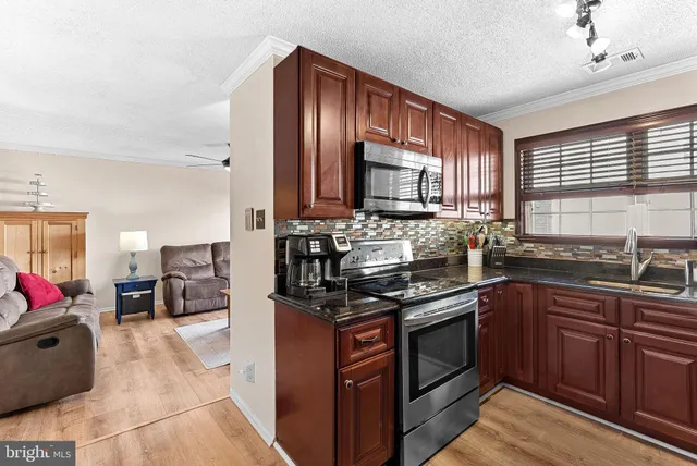 a kitchen with stainless steel appliances a stove sink microwave and cabinets