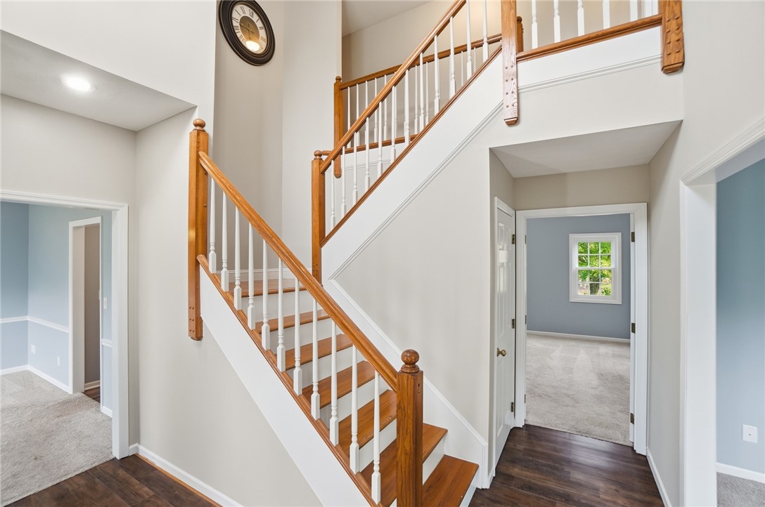 10 Chase Court Springboro, OH 45066 - Photo 9 of 75 This spacious foyer features gleaming wood floors and a grand staircase, offering a warm welcome.
