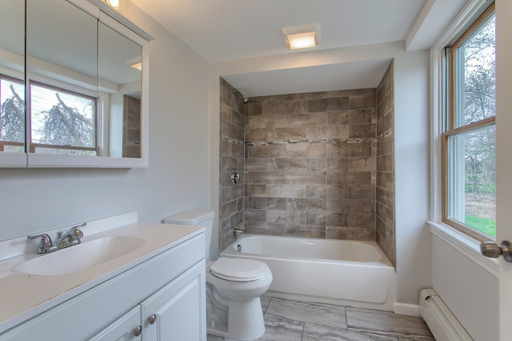18 South Martin Road Amesbury, MA 01913 - Photo 15 of 30 a bathroom with a bathtub toilet sink vanity and windows