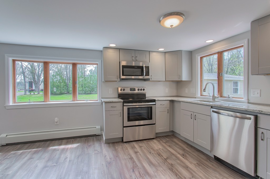 18 South Martin Road Amesbury, MA 01913 - Photo 4 of 30 a kitchen with granite countertop a stove a sink and a microwave