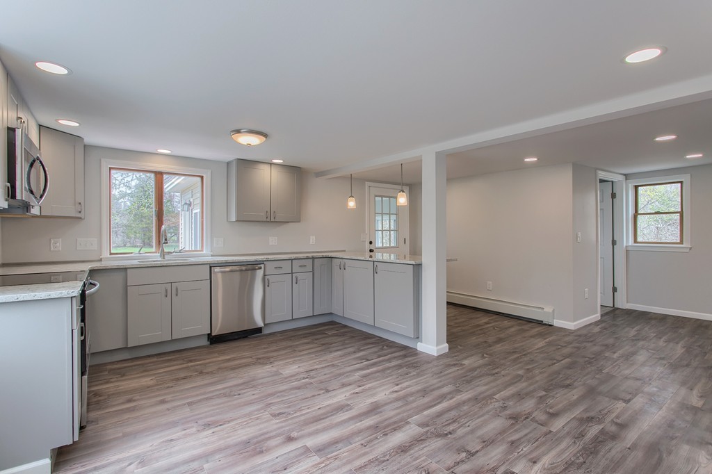 18 South Martin Road Amesbury, MA 01913 - Photo 6 of 30 a large kitchen with a wooden floor and stainless steel appliances