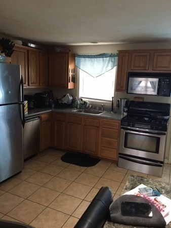 997 Middlesex Street, Unit 3 Lowell, MA 01851 - Photo 6 of 11 a kitchen with stainless steel appliances a stove a sink and a microwave