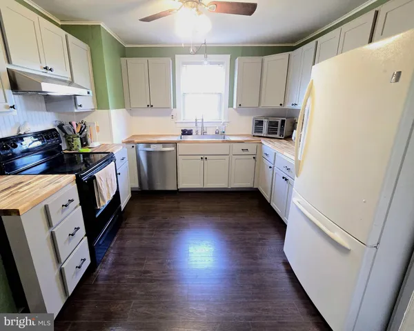 a kitchen with a sink a refrigerator a microwave and cabinets