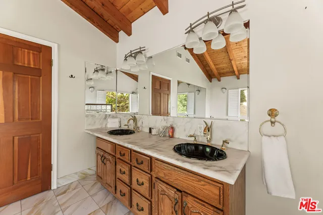 a bathroom with a stove a sink and a shower