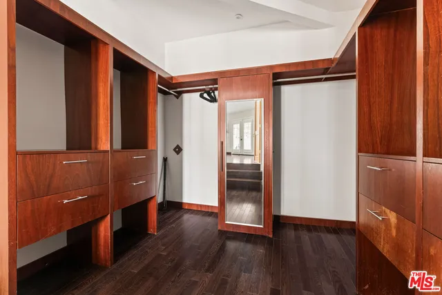 a living room with furniture large window and wooden floor