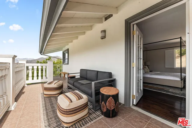 a bedroom with a bed couch and a window