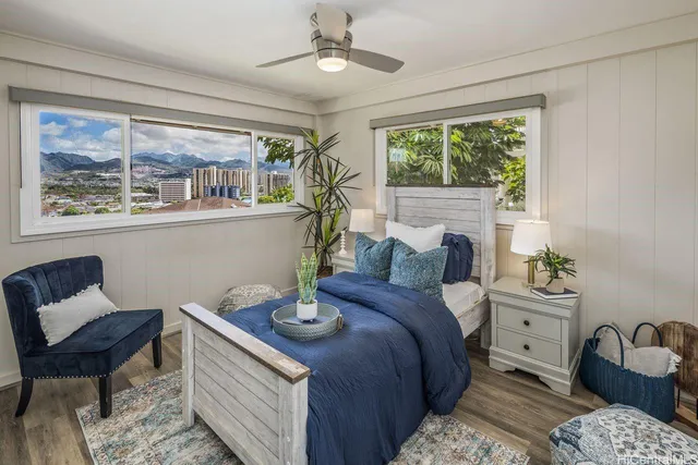 a bedroom with a bed a window and potted plant