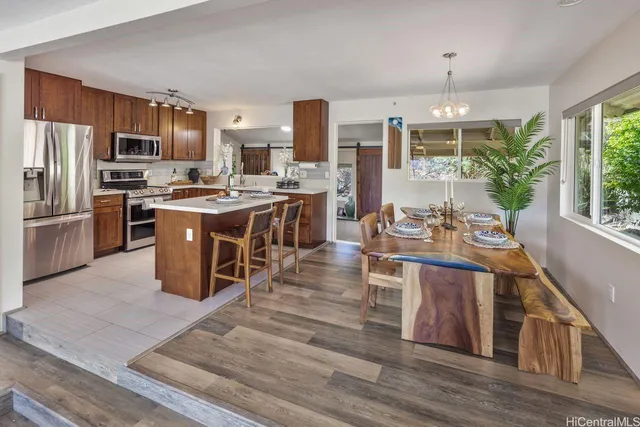 a kitchen with stainless steel appliances granite countertop a stove refrigerator and a view of living room