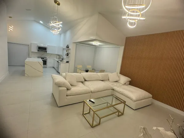 a living room with furniture and a chandelier