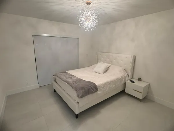 a bedroom with a bed and a chandelier