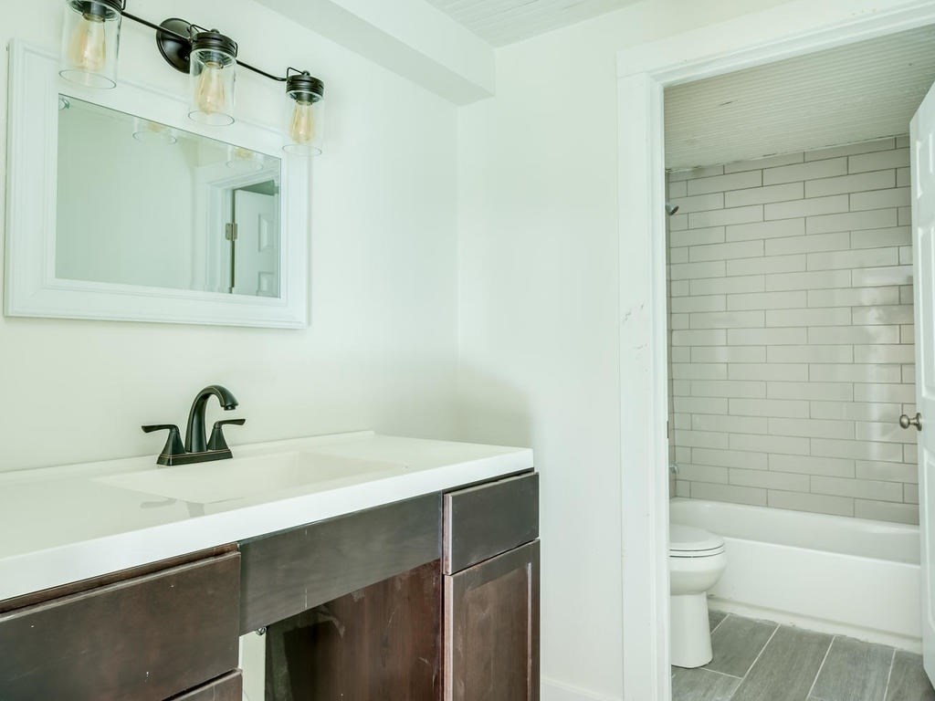 110 South Main Street, Unit 104 Elgin, TX 78621 - Photo 16 of 20 a bathroom with a sink a toilet and a bathtub