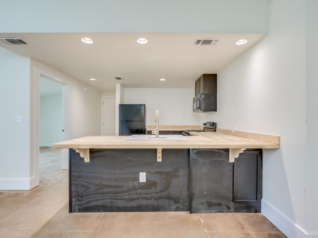 110 South Main Street, Unit 104 Elgin, TX 78621 - Photo 18 of 19 a view of a kitchen with a sink and chairs