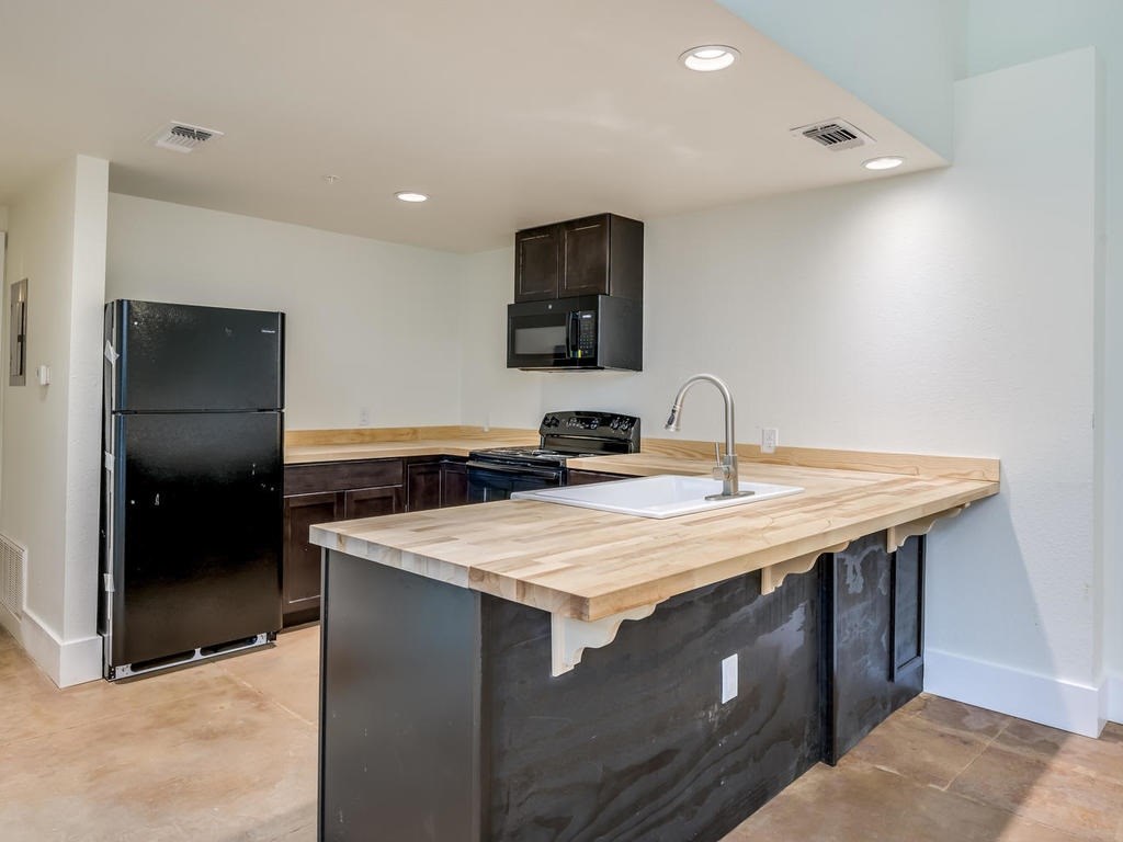 110 South Main Street, Unit 104 Elgin, TX 78621 - Photo 4 of 20 a kitchen with a sink and a refrigerator