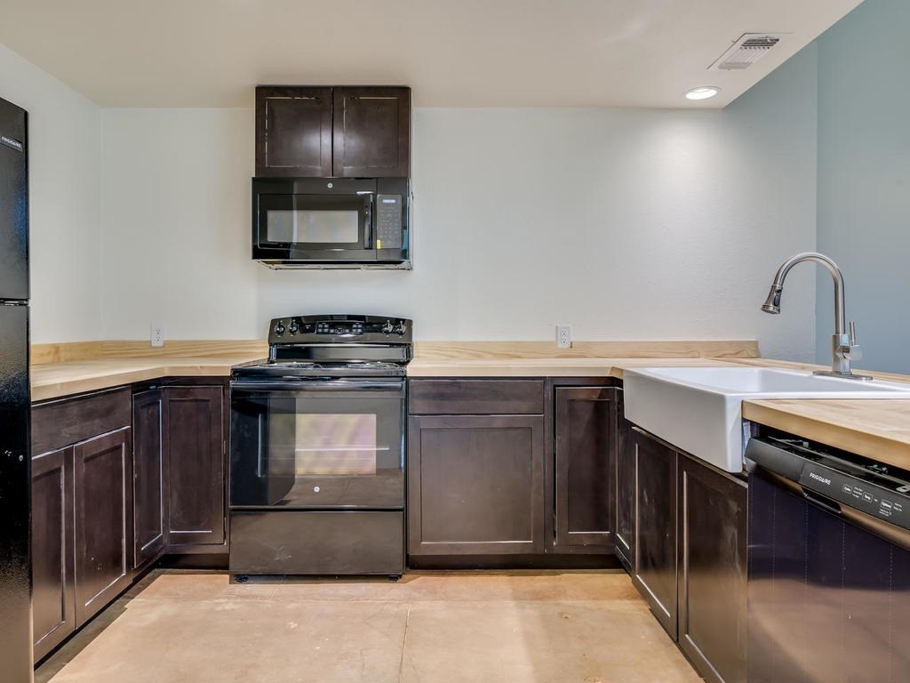 110 South Main Street, Unit 104 Elgin, TX 78621 - Photo 5 of 19 a kitchen with a stove and a sink