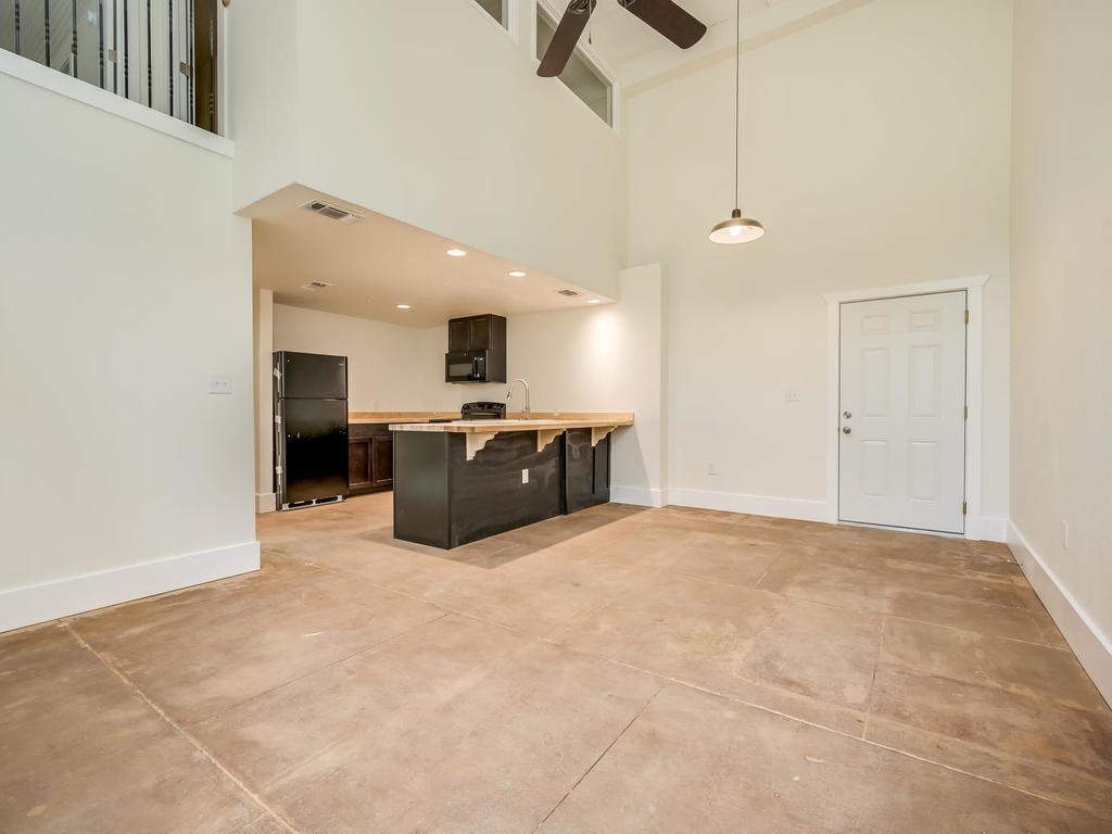 110 South Main Street, Unit 104 Elgin, TX 78621 - Photo 7 of 19 a large kitchen with cabinets and stainless steel appliances