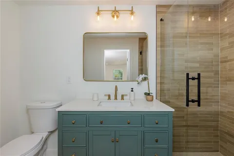 a bathroom with a toilet a sink and mirror