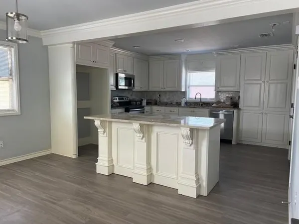 a kitchen with white cabinets and stainless steel appliances