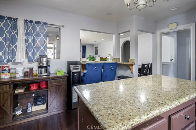 a kitchen with stainless steel appliances wooden floor and living room view