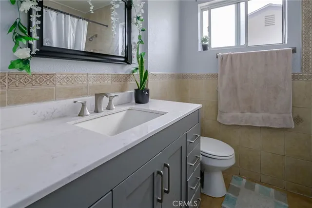 a bathroom with a sink a toilet and mirror