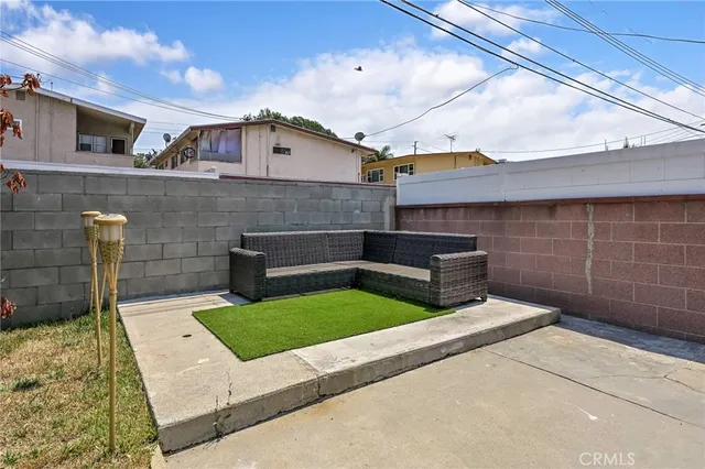 a view of backyard with barbeque grill and seating area