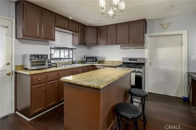 a kitchen with stainless steel appliances granite countertop a stove refrigerator sink and cabinets