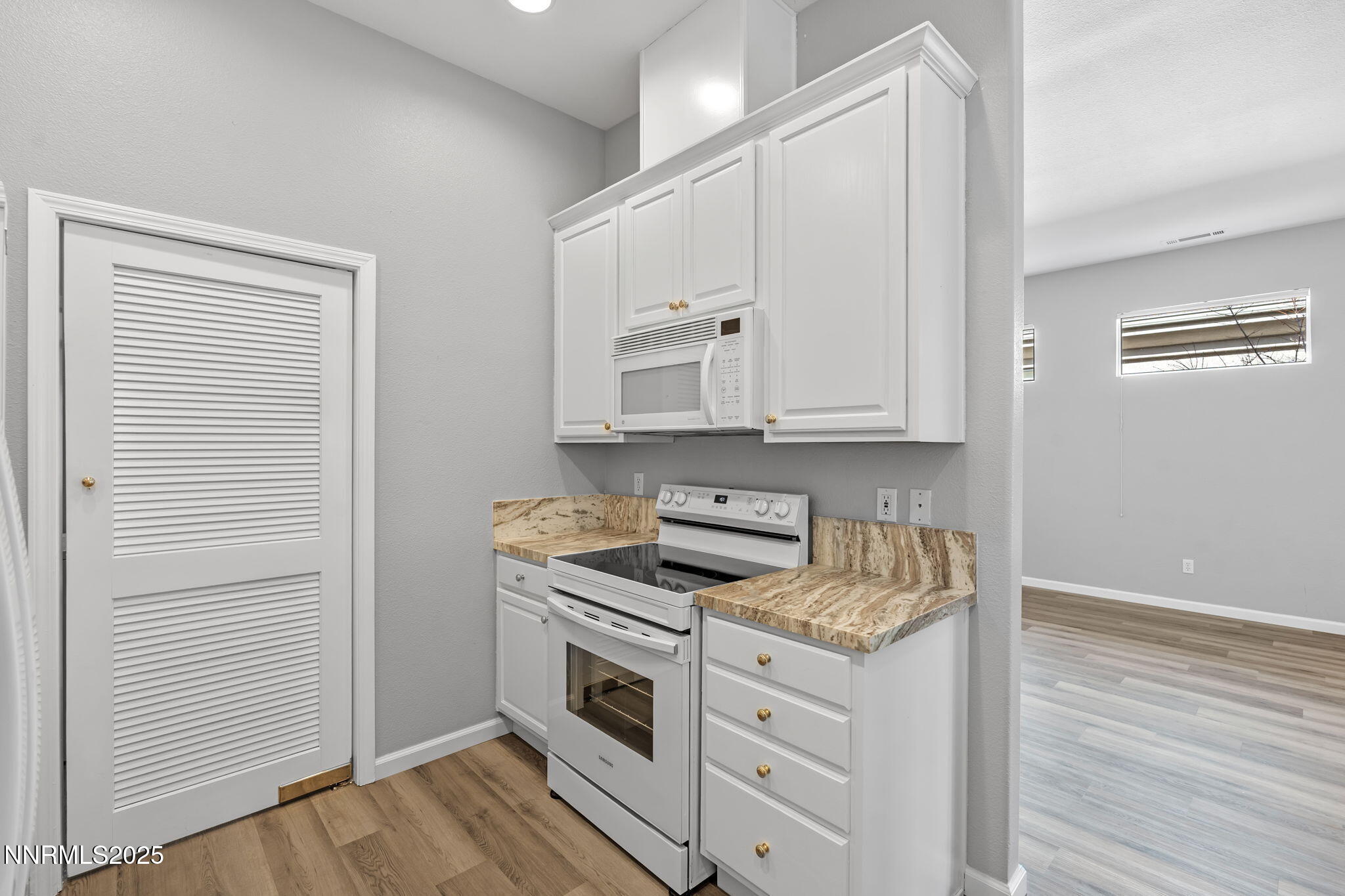 412 Sierra Leaf Circle Reno, NV 89511 - Photo 17 of 36 a kitchen with granite countertop white cabinets and white appliances