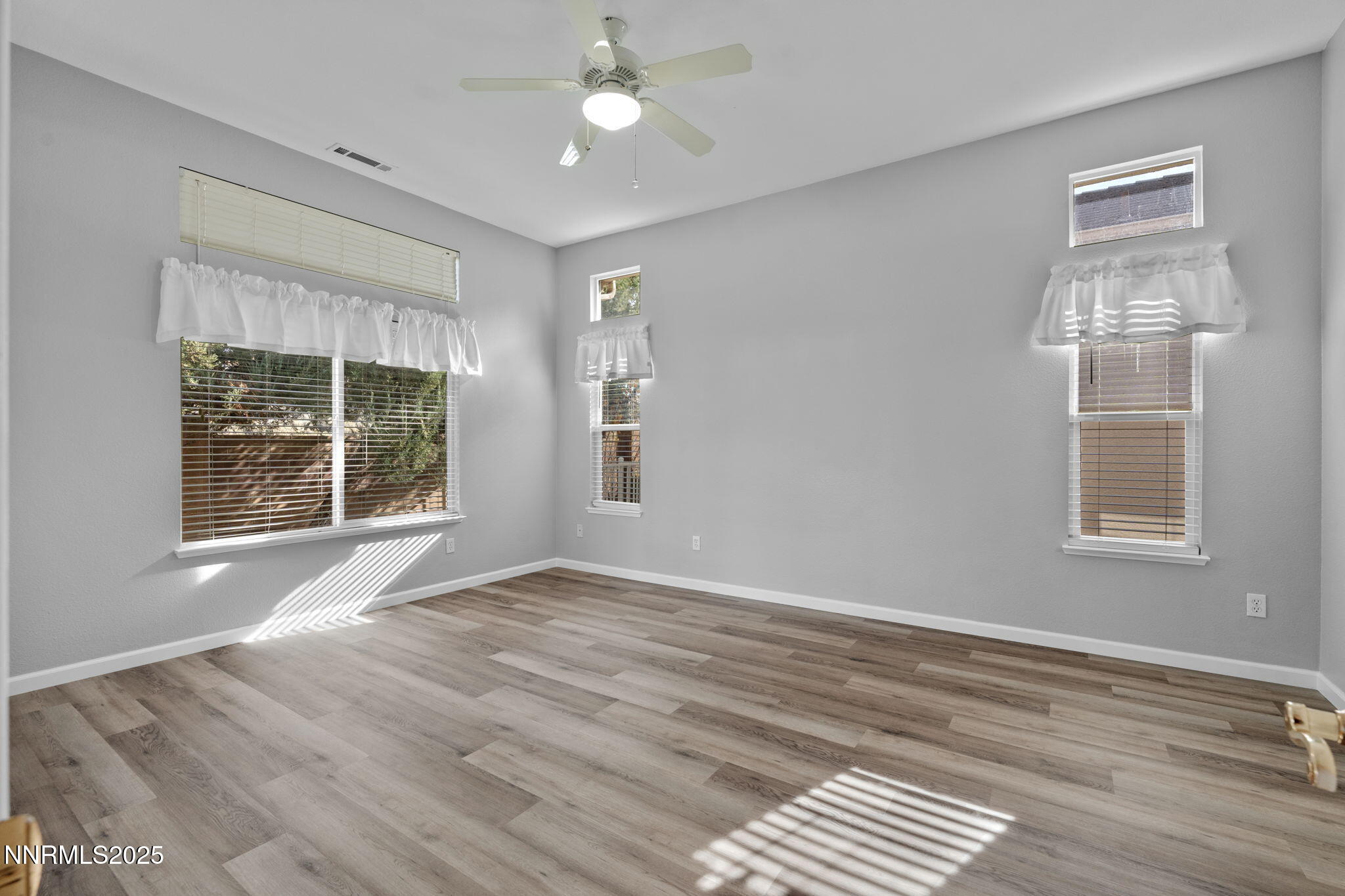 412 Sierra Leaf Circle Reno, NV 89511 - Photo 22 of 36 a view of an empty room with a window and wooden floor