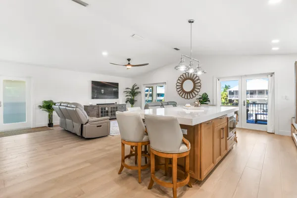 a kitchen with a dining table chairs stove and white cabinets
