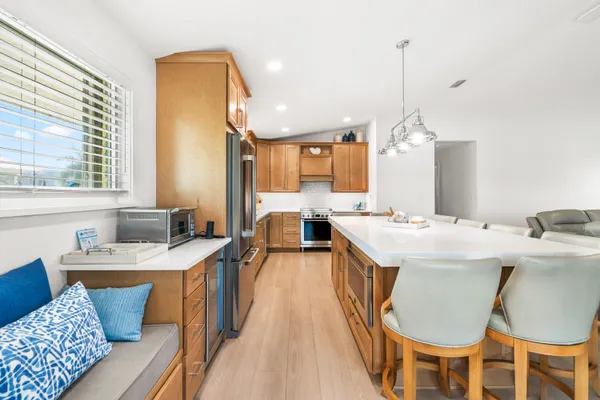 a large kitchen with cabinets a sink a counter space and stainless steel appliances