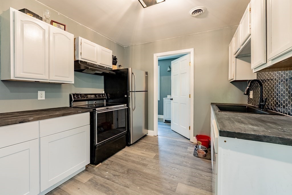 272 Denver Street Springfield, MA 01109 - Photo 6 of 32 a kitchen with granite countertop a stove and a sink
