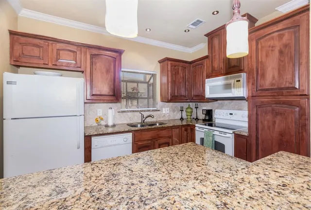 a kitchen with stainless steel appliances granite countertop a refrigerator sink stove microwave and cabinets