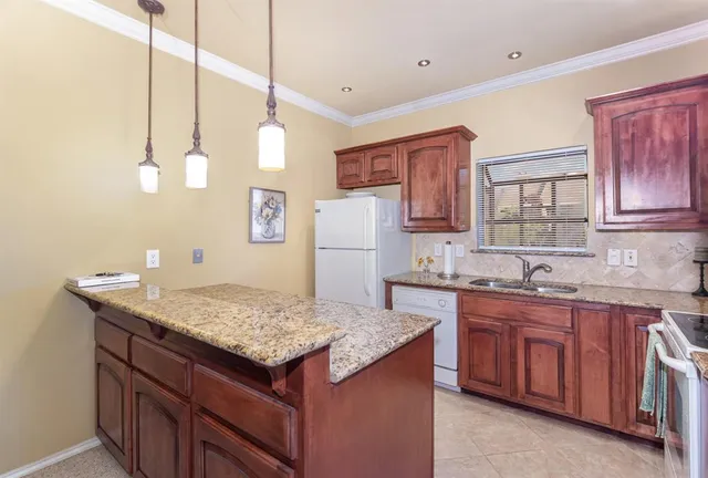 a kitchen with a sink refrigerator and cabinets