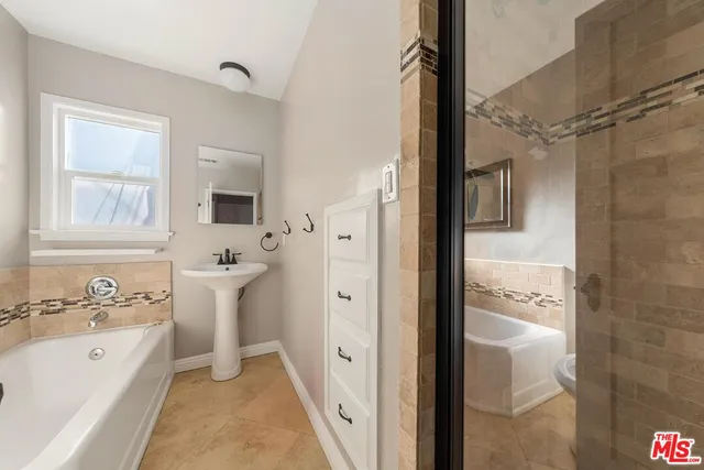 a bathroom with a bathtub shower sink and toilet