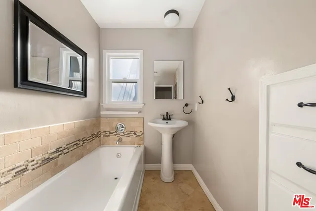 a bathroom with a bathtub sink and mirror