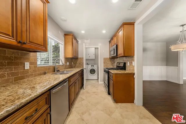 a kitchen with stainless steel appliances granite countertop a sink stove and refrigerator