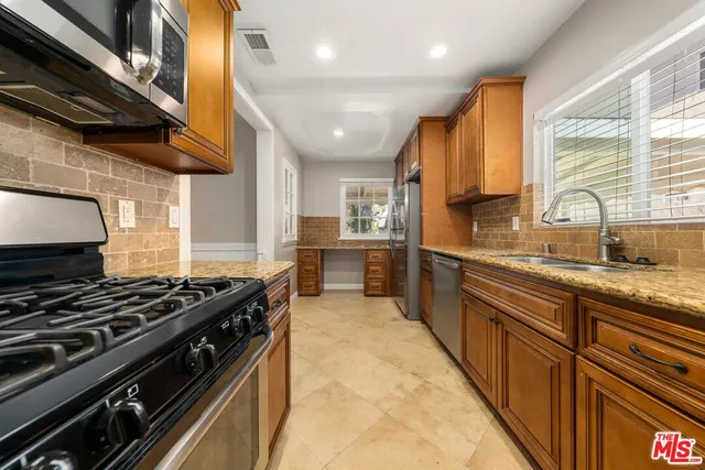 a kitchen with stainless steel appliances granite countertop a stove and a sink
