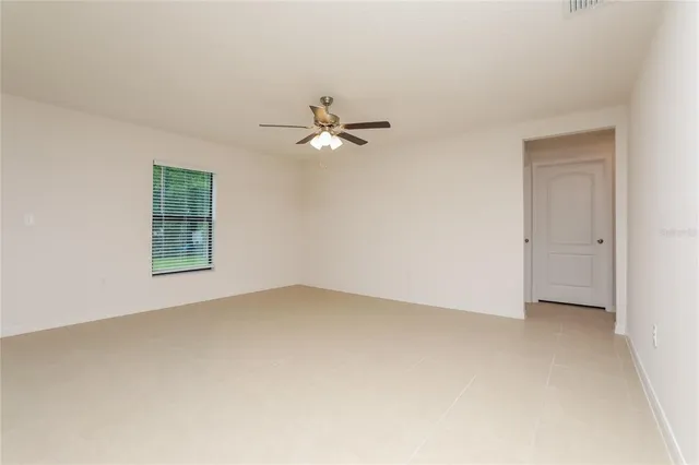an empty room with fan and windows
