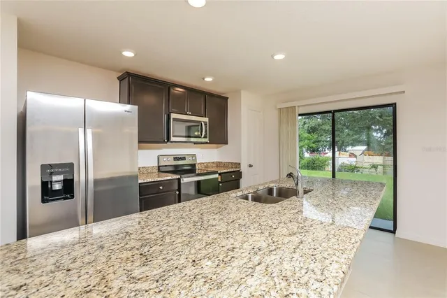 a kitchen with granite countertop a refrigerator and a sink