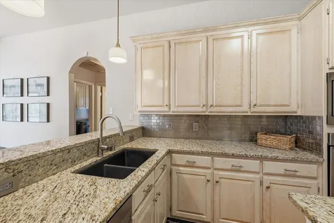 a kitchen with granite countertop a sink stainless steel appliances and cabinets